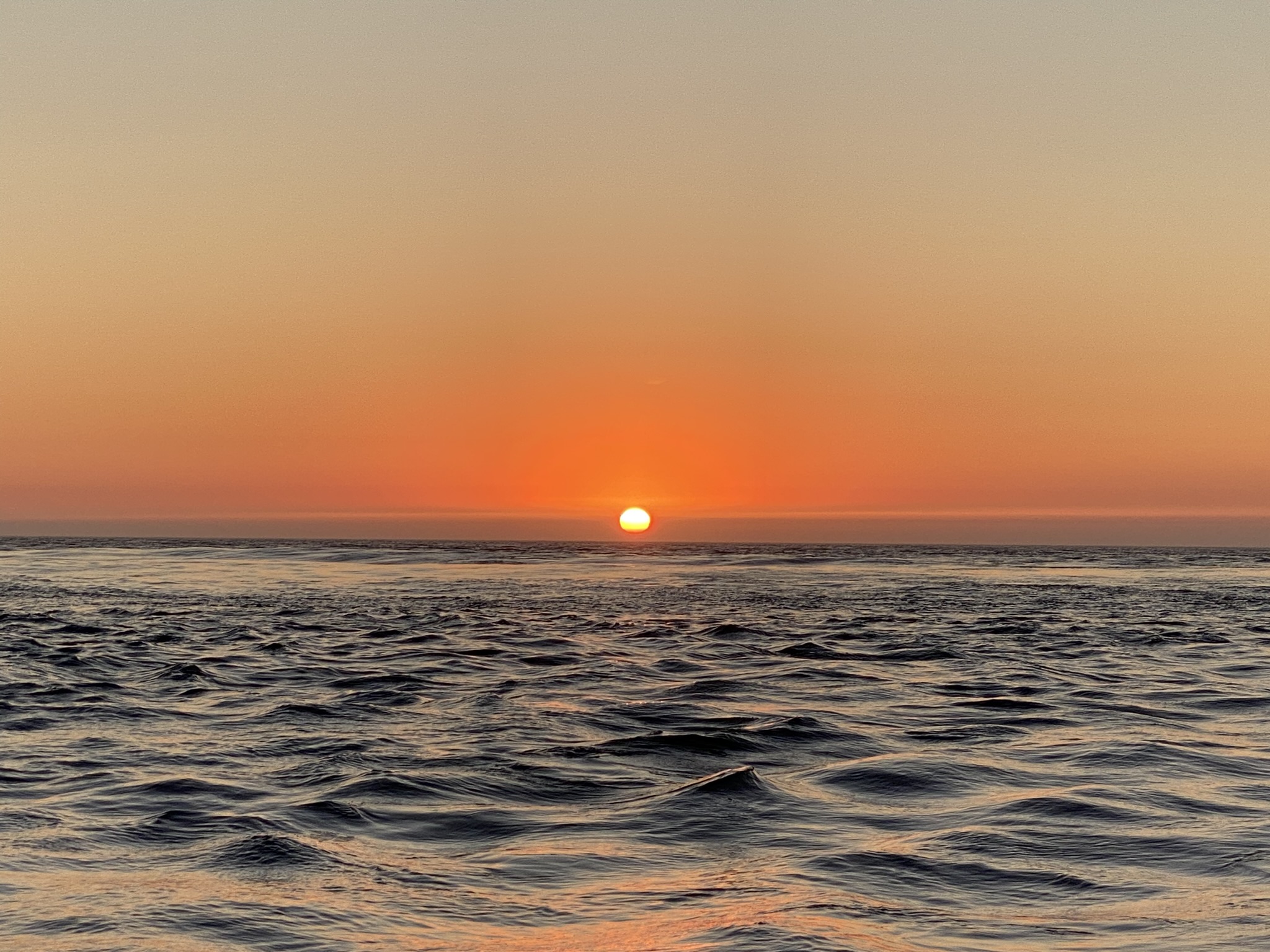 Golden sunset over the Douro River seen from a sailboat in Porto