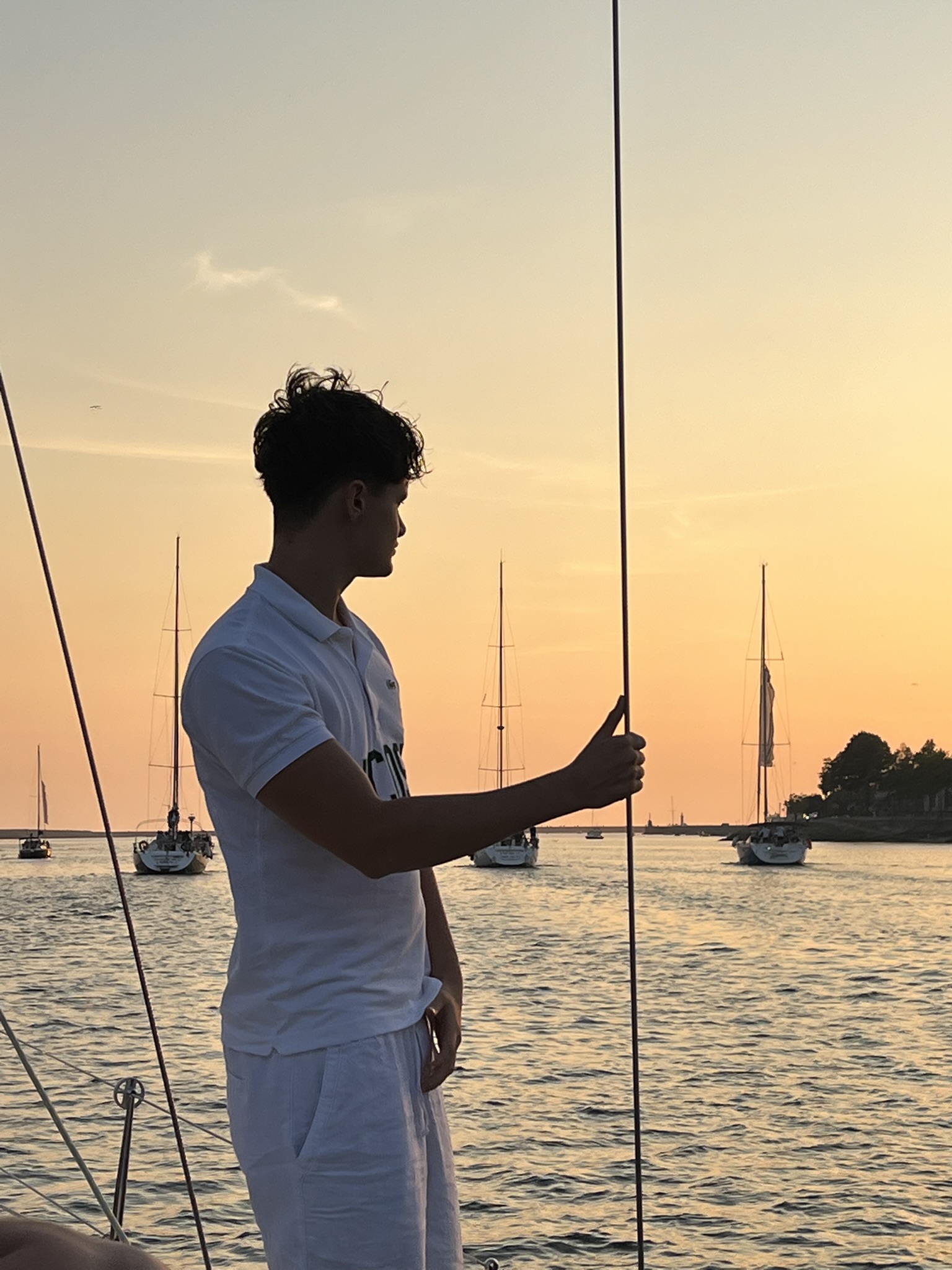 Guests enjoying a Port tonic at sunset aboard a Port Sailors sailboat