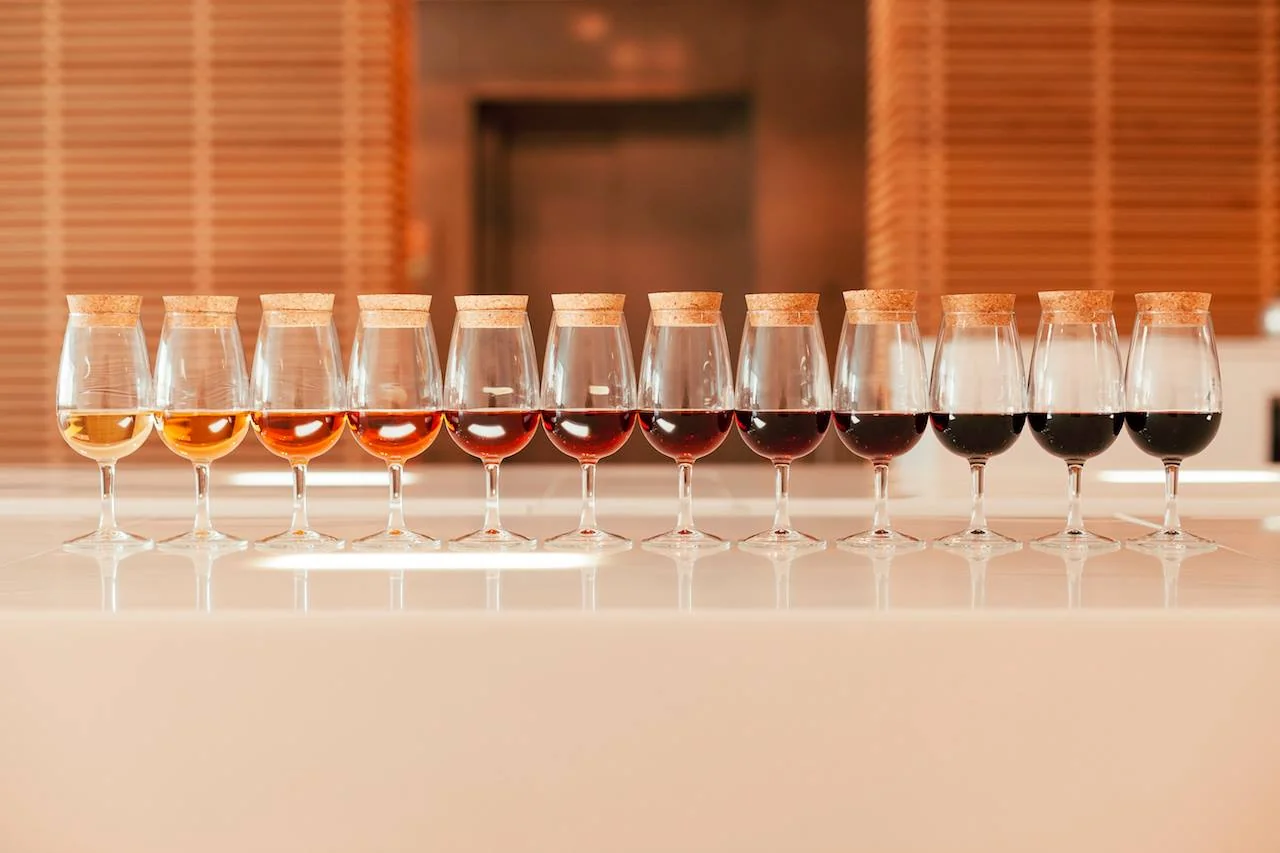 A row of tasting glasses showing Port wine graduating from white to deep ruby and tawny