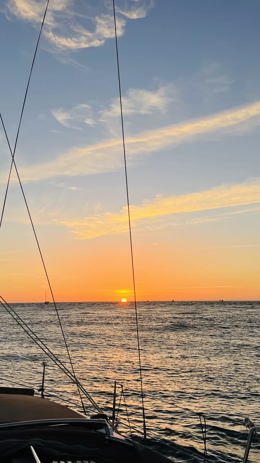 Dramatic Atlantic sunset seen from the bow of a sailboat off Porto