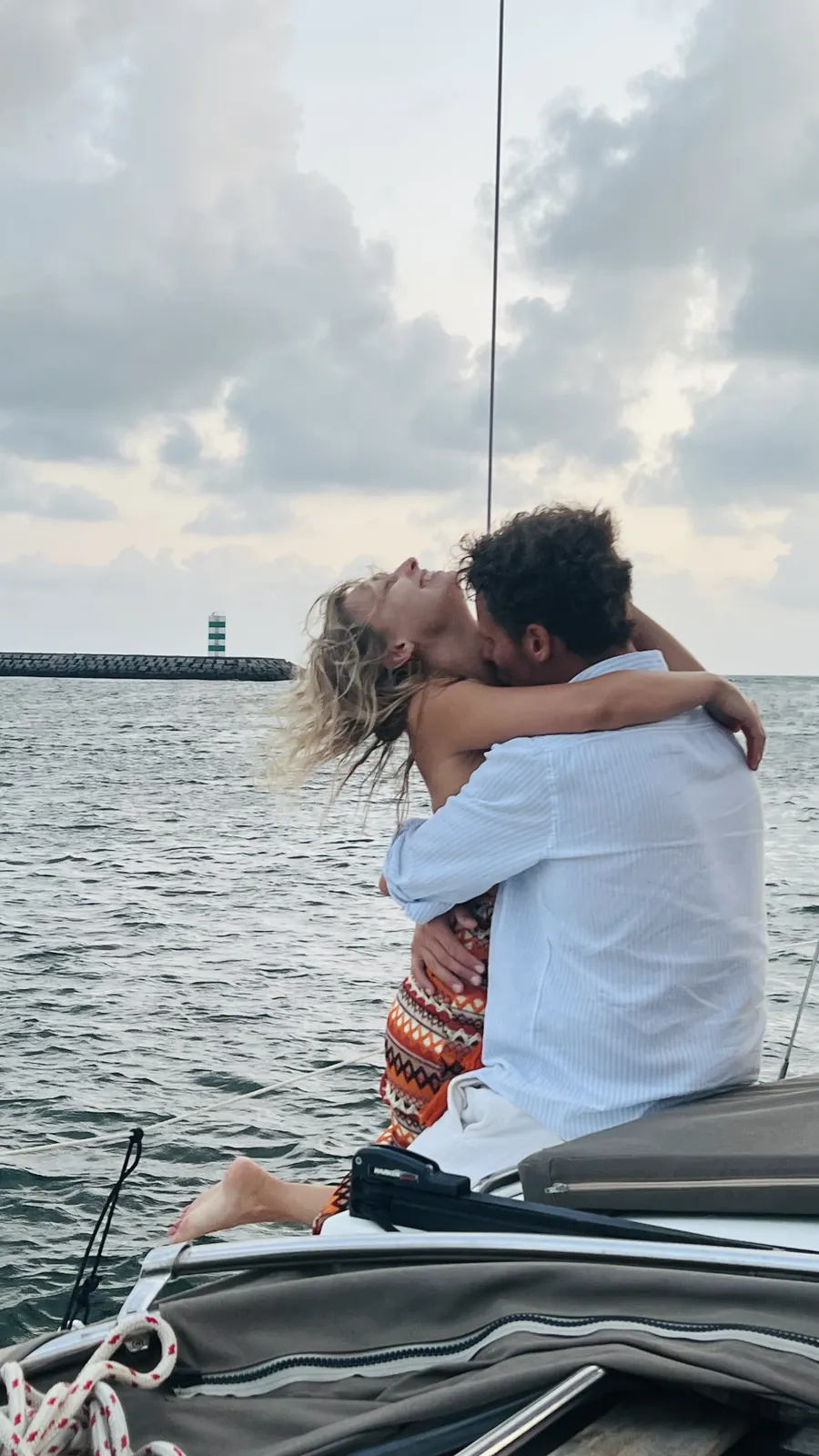 Couple kissing on deck by the Foz lighthouse during a sunset cruise in Porto