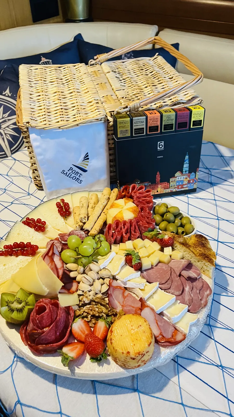 Port Sailors gourmet charcuterie board with cured meats, cheese and fruit on a Porto sailboat